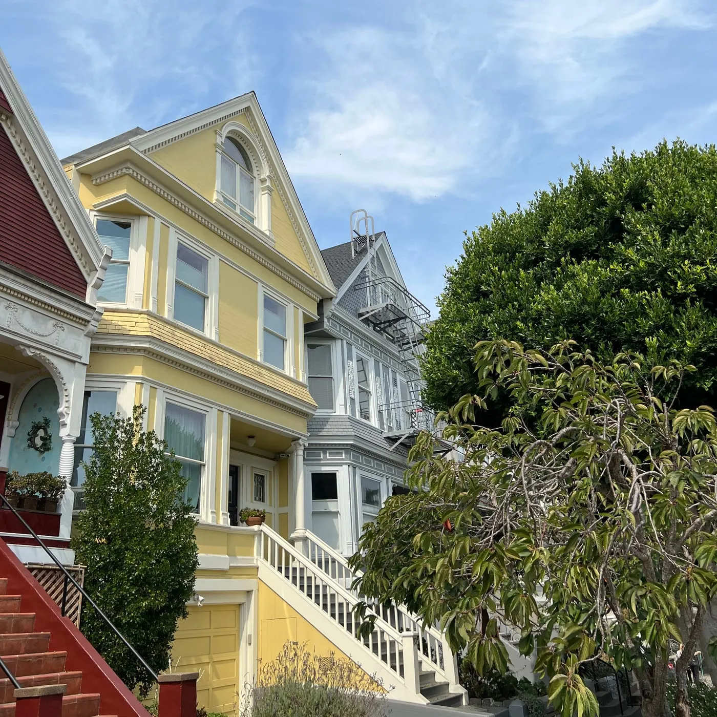 Pale yellow San Francisco Victorian with white trim and a repainted staircase